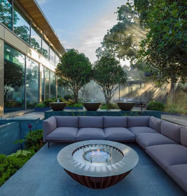 Outdoor seating area around firepit, next to infinity spa pool designed by Ann-Marie Powell Gardens