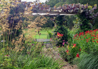 Discreet dining area with wood pergola and large flower borders  - Country style garden designed by Ann- Marie Powell, UK 2013